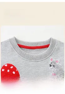 Détail d'un sweat gris pour enfant avec col côtelé rouge et broderie d'animaux