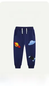 Detail of space-themed embroidery with UFO and rocket patterns on cotton pants