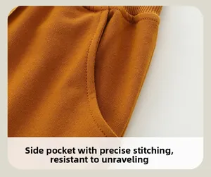 Close-up of side pocket on ginger yellow knit pants with neat stitching and soft texture