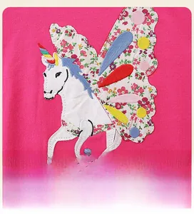 Macro detail of unicorn patch embroidery and floral wing on kids pink sweatshirt