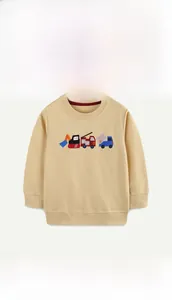 Detail of embroidered construction vehicles on mustard yellow cotton kid's sweatshirt