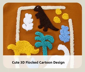 Detailed view of colorful 3D chenille dinosaur patches on ginger orange sweatshirt fabric
