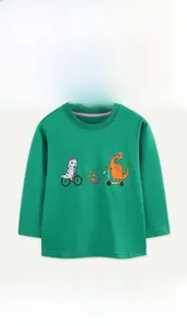 Detail of vibrant green cotton t-shirt featuring playful cartoon dinosaur prints