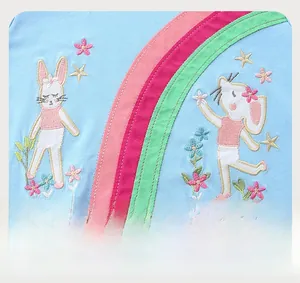 Detail of baby blue cotton dress featuring exquisite cartoon rabbit and rainbow embroidery