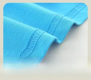 Detail of light blue knit hem showing precise double-needle stitching and fabric texture