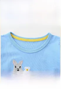 Détail du col rond côtelé et de la broderie de lapin sur une robe en maille pour fille