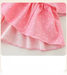 Detailed view of pink white polka dot dress hem with tiered ruffle and neat stitching