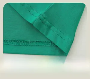 Close-up of double-stitched hem on green cotton t-shirt with high quality craftsmanship