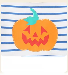 Détail du tissu en tricot rayé bleu et blanc avec un motif de citrouille orange