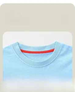 Detail of blue dinosaur t-shirt neckline with red reinforced seam and soft cotton fabric