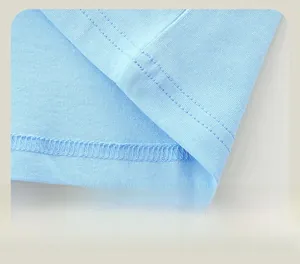 Close-up of double-stitched hem and fine seams on light blue cotton dinosaur sweatshirt
