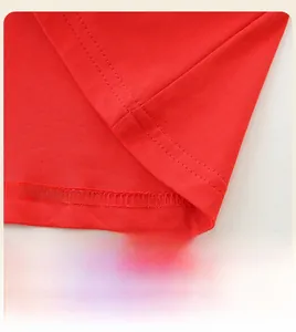 Vista dettagliata dell'orlo dell'abito rosso a trapezio con cuciture precise in cotone