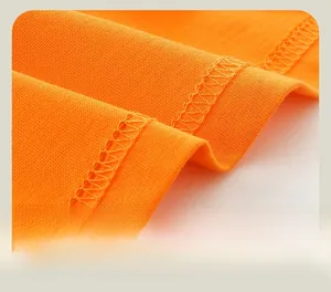 Detailed close-up of fine orange knit fabric and precision hem stitching on boy shirt