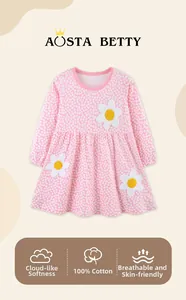 Dettaglio dell'abito da bambina in cotone rosa con ricamo di margherite e tessuto traspirante