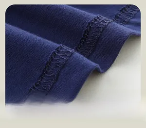 Détail des coutures soignées à double aiguille sur l'ourlet du t-shirt bleu marine