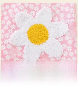 Dettaglio dell'abito in cotone rosa con stampa di margherite e ricamo floreale 3D in rilievo