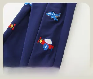 Detail von Flugzeug-Stickerei auf dunkelblauer Baumwoll-Jogginghose für Jungen