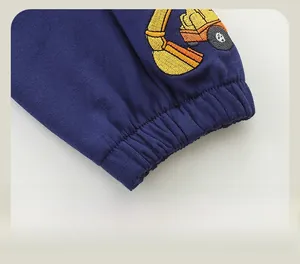 Detailaufnahme der elastischen Rippbündchen und Bagger-Stickerei an Jungen-Baumwollhosen