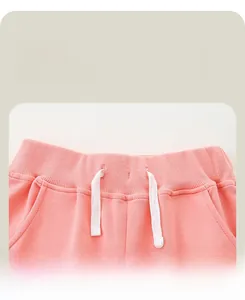 Detail view of pink girl's joggers featuring elastic waistband and white drawstrings