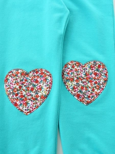 Girls fashion joggers in teal green with colorful floral heart patches and ribbed cuffs