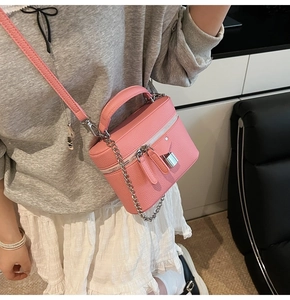 Detailed view of pink lychee leather crossbody bag with silver chain and metal lock