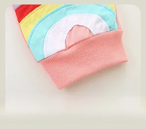 Detail of pink ribbed cuffs and colorful rainbow embroidery on girls' cotton joggers