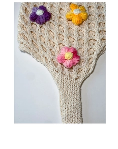 Detail of cream crochet shoulder bag featuring colorful 3D floral knit embellishments