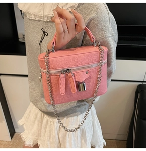 Detail of pink lychee leather vanity case with silver chain strap and metal padlock decor