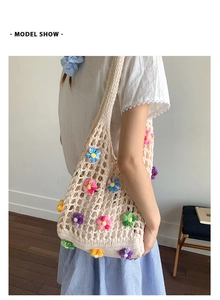 Detail of handmade crochet shoulder bag featuring colorful 3D knitted flower decorations