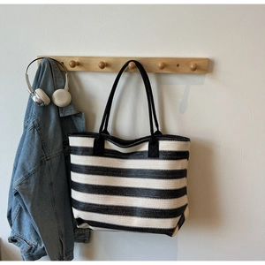 Gros plan du sac cabas tissé à rayures noires et blanches avec bretelles solides