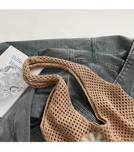 Détail du sac à bandoulière tissé ajouré avec motifs de fleurs et sangle confortable