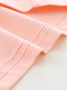 Gros plan d'un t-shirt rose en coton à manches longues avec détails de couture overlock