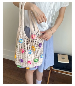 Close-up of handmade crochet tote bag featuring 3D colorful flowers for summer outfits