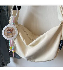 Detail of beige nylon crossbody bag featuring a cute Capybara charm and beaded strap