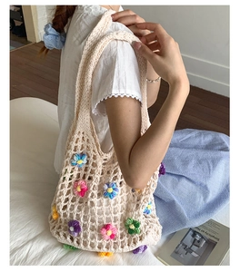 Detail of handmade woven beach tote bag with colorful 3D knitted flower decorations