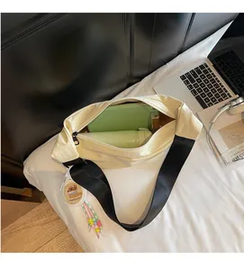 Detail view of large interior capacity for cream crossbody dumpling bag with accessories