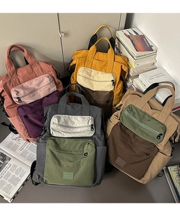 Detail of multi-color nylon backpacks with front zip pockets and academic props