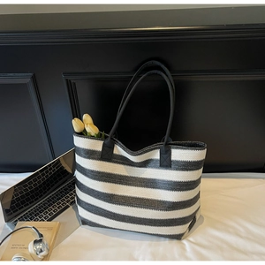 Vue détaillée du sac cabas tissé à rayures noires et blanches avec de grandes bandoulières