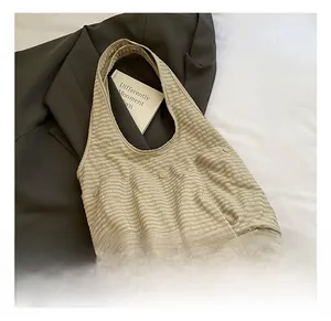 Detail shot of checkered canvas tote bag showing buttoned front pockets and wide straps