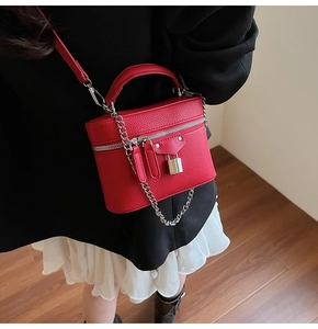 Macro detail of red lychee pattern handbag with silver hardware and decorative chain