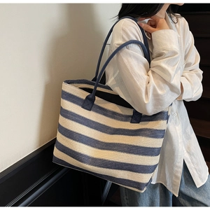 Gros plan d'un sac cabas tissé à rayures bleues et blanches montrant la texture fine
