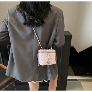 Dettaglio mini borsa trapuntata rosa con borchie di cristallo e tracolla a catena argento