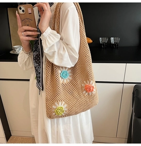 Détail d'un sac cabas en maille tissée à la main avec fleurs en crochet 3D colorées