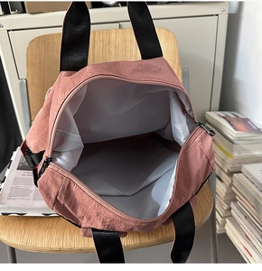 Detail of spacious interior and smooth double metal zipper closure on the pink tote bag