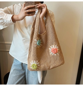 Gros plan détaillé d'un sac cabas en crochet fait main avec trois fleurs 3D aux tons pastels