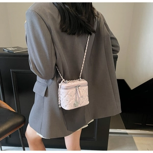 Dettaglio posteriore della mini borsa trapuntata rosa con tracolla a catena e camelia