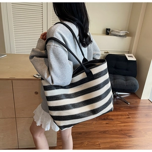 Gros plan d'un sac cabas tissé léger avec des rayures horizontales noires et blanches