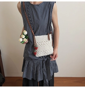 Detailed knit of white handmade crochet crossbody bag featuring strawberry charms