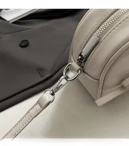 Gros plan détaillé des ferrures en argent poli et de la texture du cuir sur un sac beige