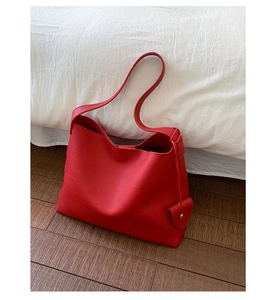 Dettaglio borsa tote in pelle martellata rossa con tracolla larga e fibbia in metallo